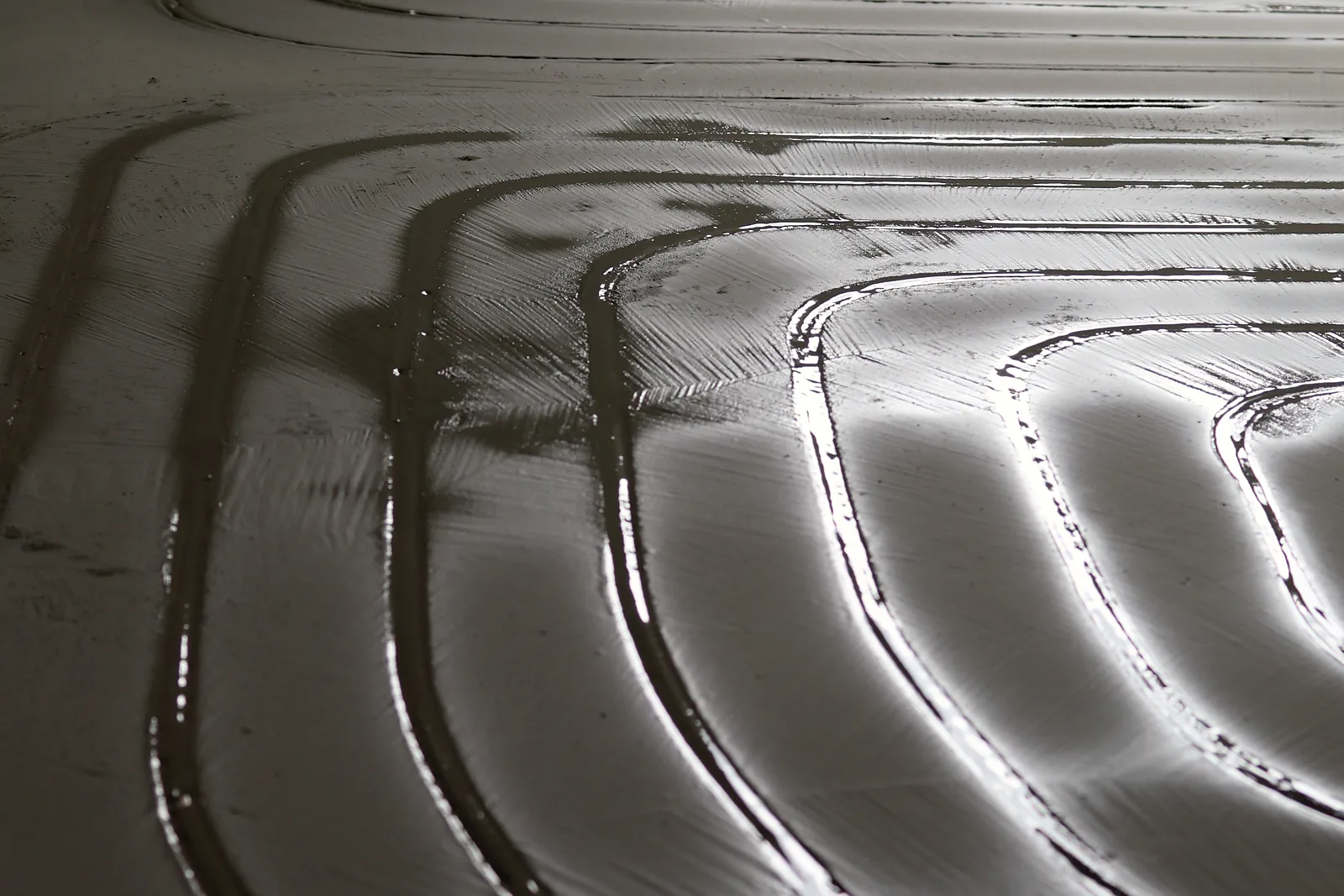 Nasse, glänzende Kanäle in Spiralform, die Masse bildet Schleifen im Streiflicht