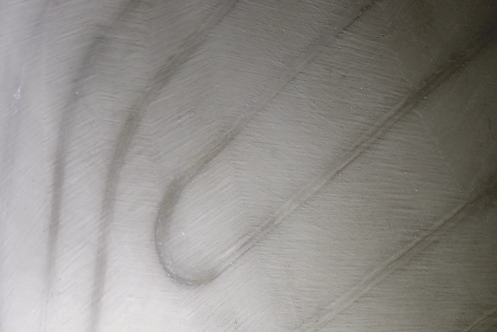 Mattgraue, glatte Fläche, auf der die Bögen der Heizkreise nur noch schwach zu erkennen sind